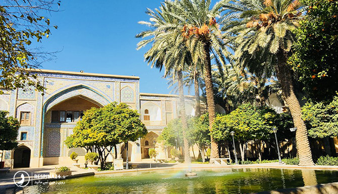 نمای روبروی مدرسه خان با درختان سرسبز و حوض