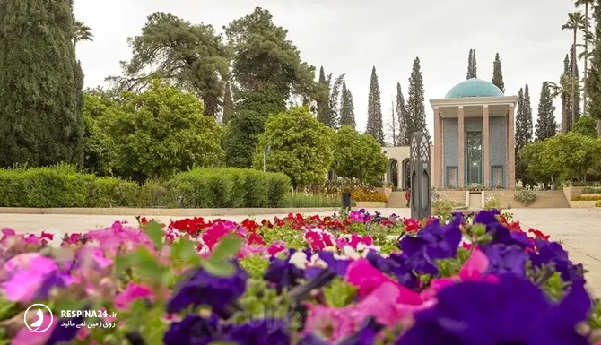 نمایی از سعدیه در بهار با درختان سرسبز و گل های رنگارنگ و ساختمان اصلی